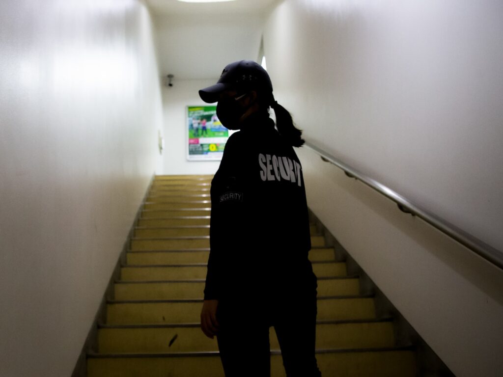 a person in a black uniform walking up a flight of stairs